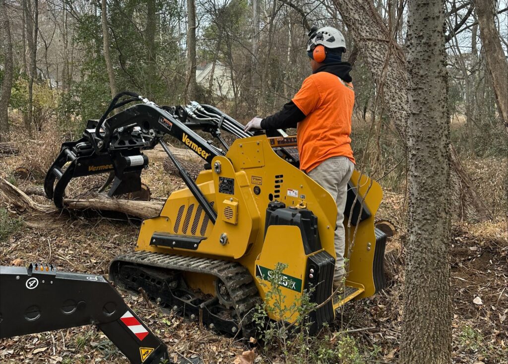 Mini skid steer machine used for efficient tree removal and cleanup by AAA Tree Experts